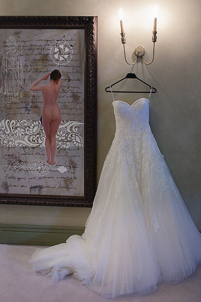 Les Ottomans wedding dress hanging on the wall next to painting of naked girl