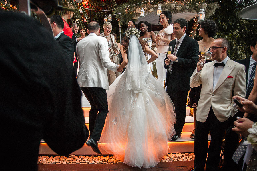 Bride and groom climbing to ceremony area at backyard wedding