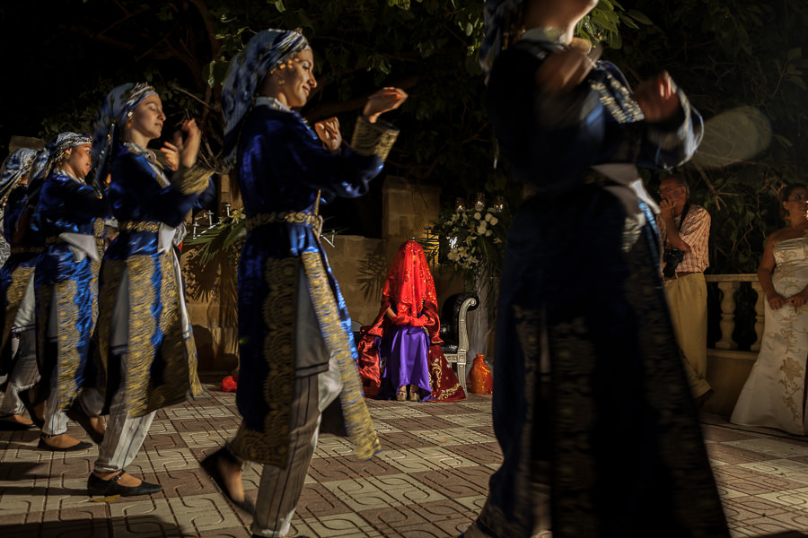 bride watching folk dancers at henna night