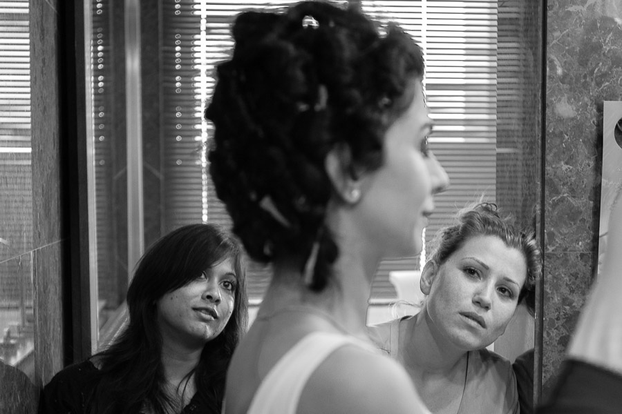 Friends of bride watching as she is getting her make up done