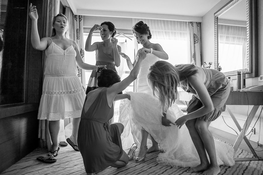 Friends helping bride putting her shoes on