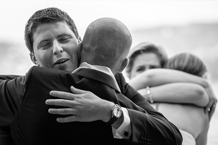 brother of bride hugs groom