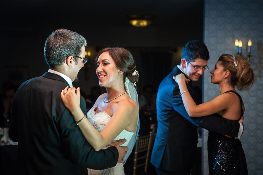 bride dancing with brother while groom dancing with sister