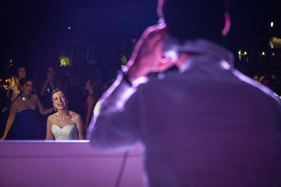 bride watching groom in dj cabin