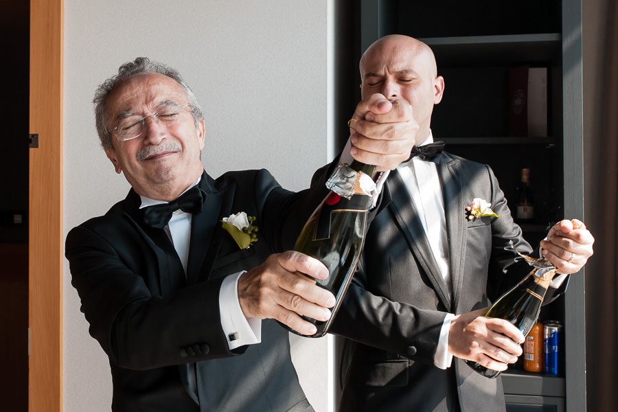 Opening a champagne at DoubleTree Hilton Moda wedding