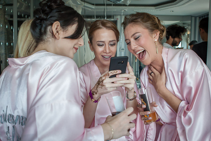 Bridesmaids laugh looking at the phone