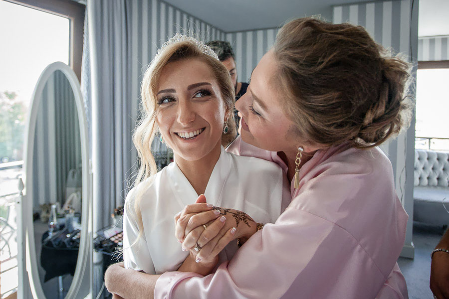 Bridesmaid hugs the bride