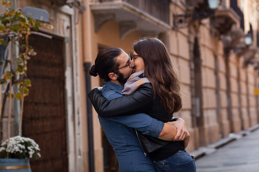 boy lifting girl and kissing on the street