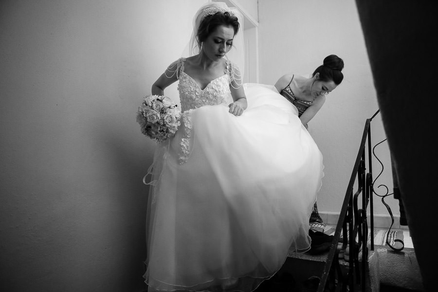 Sister helping bride to get down the stairs