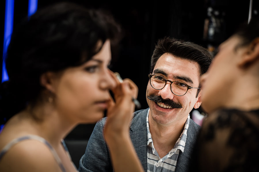 groom watching bride's preparations