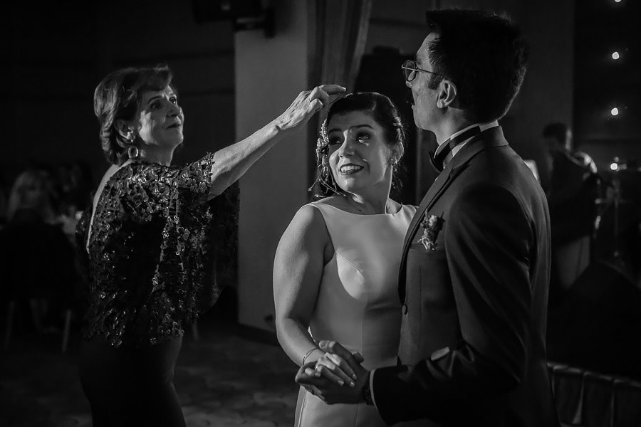 Aunt picking up confetti from bride's hair during first dance