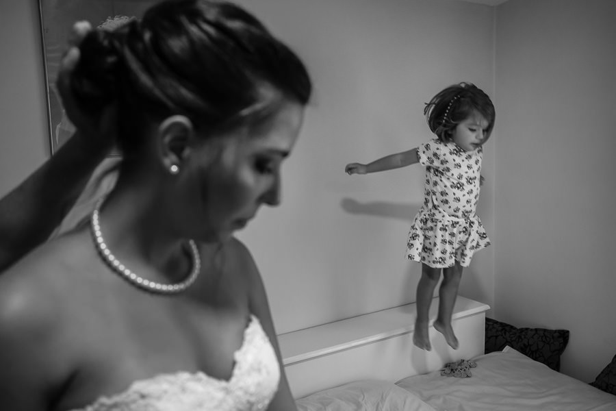 little girl jumping while bride is getting ready