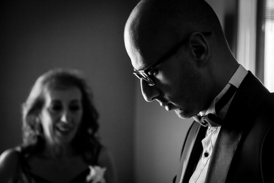 groom getting ready with mom on the background